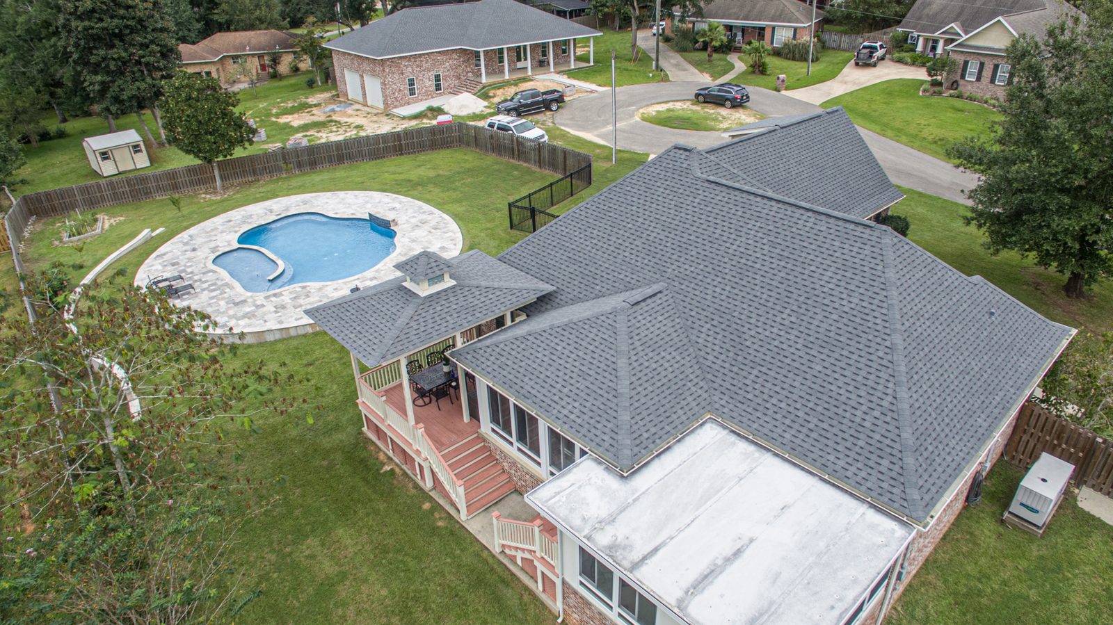 Close aerial view of a finished architectural shingle roof showing straight courses and clean ridge lines on a Mississippi Gulf Coast home