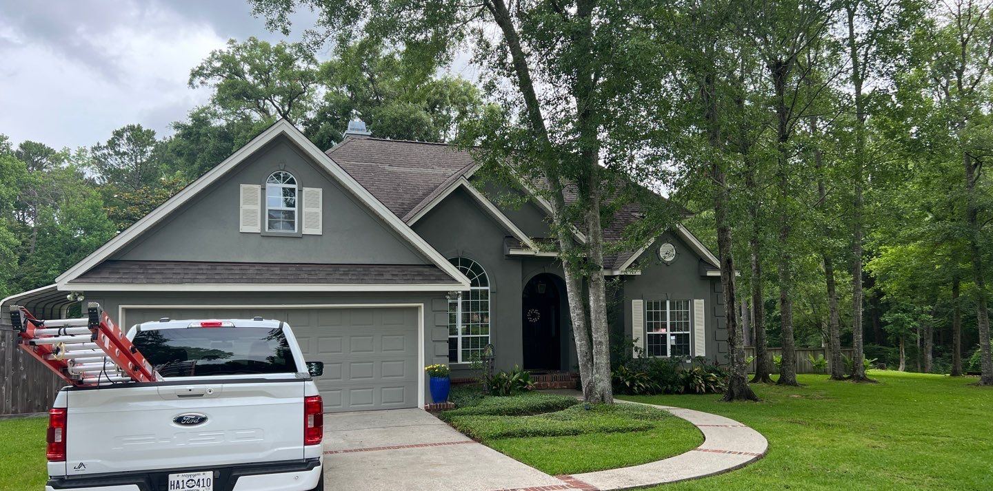 The Biloxi home from the drive with its worn, streaked shingle roof before the Habitat program replacement