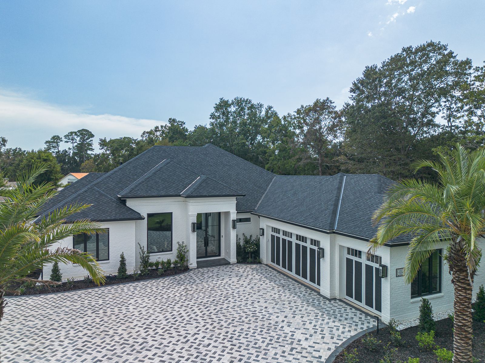 Aerial of a new white Ocean Springs home with a charcoal CertainTeed Presidential Shake designer shingle roof