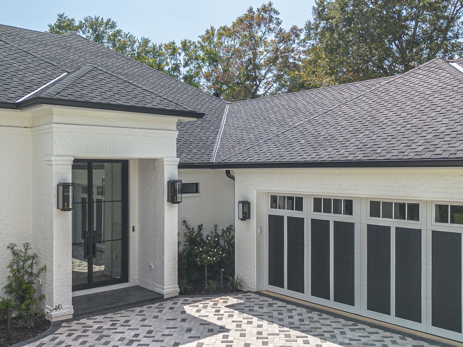 Close view of the front entry and eave line of the new home beneath the designer shingle roof