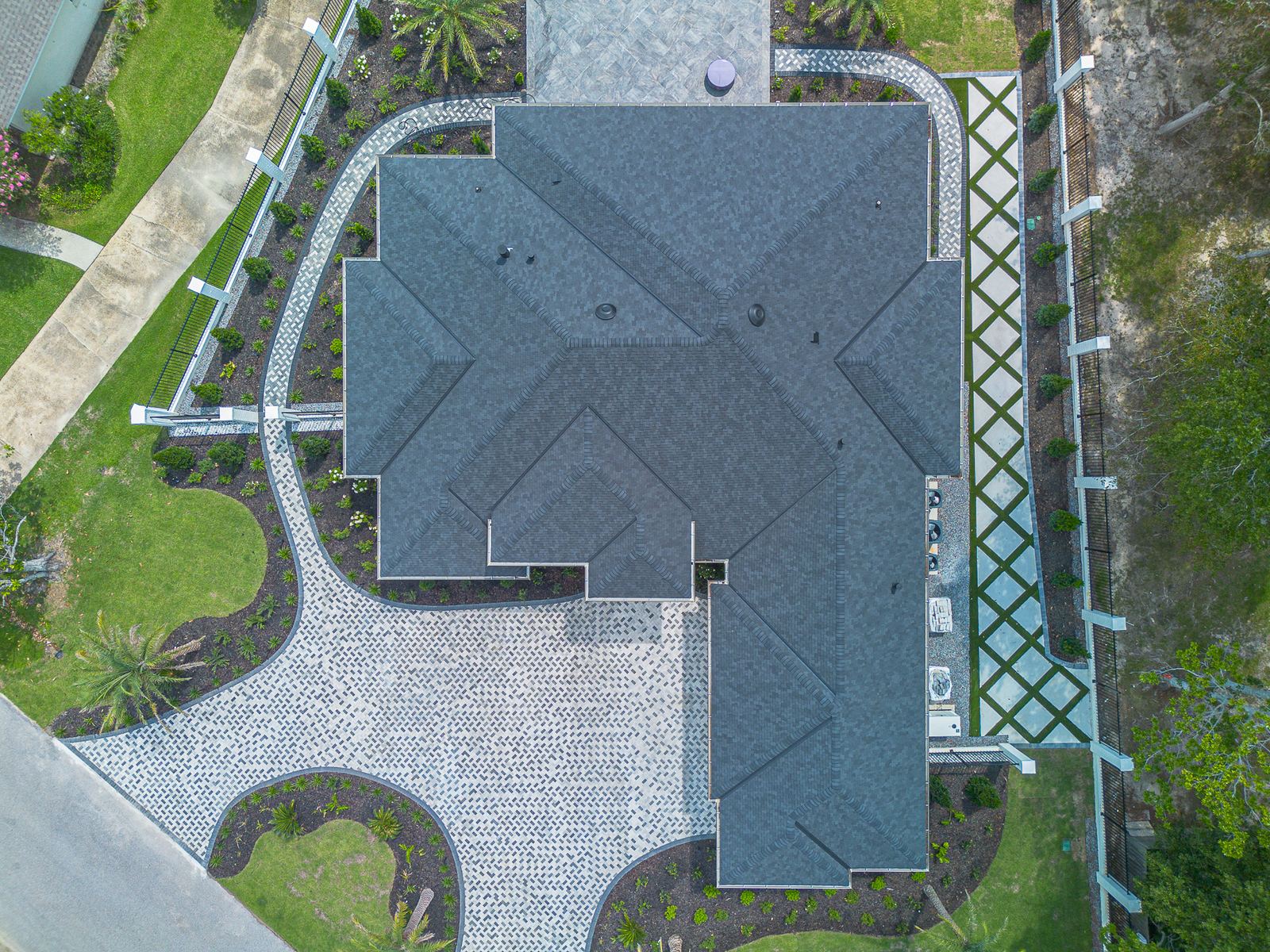 Straight-down aerial of the new home showing the full roof plan in charcoal designer shingles