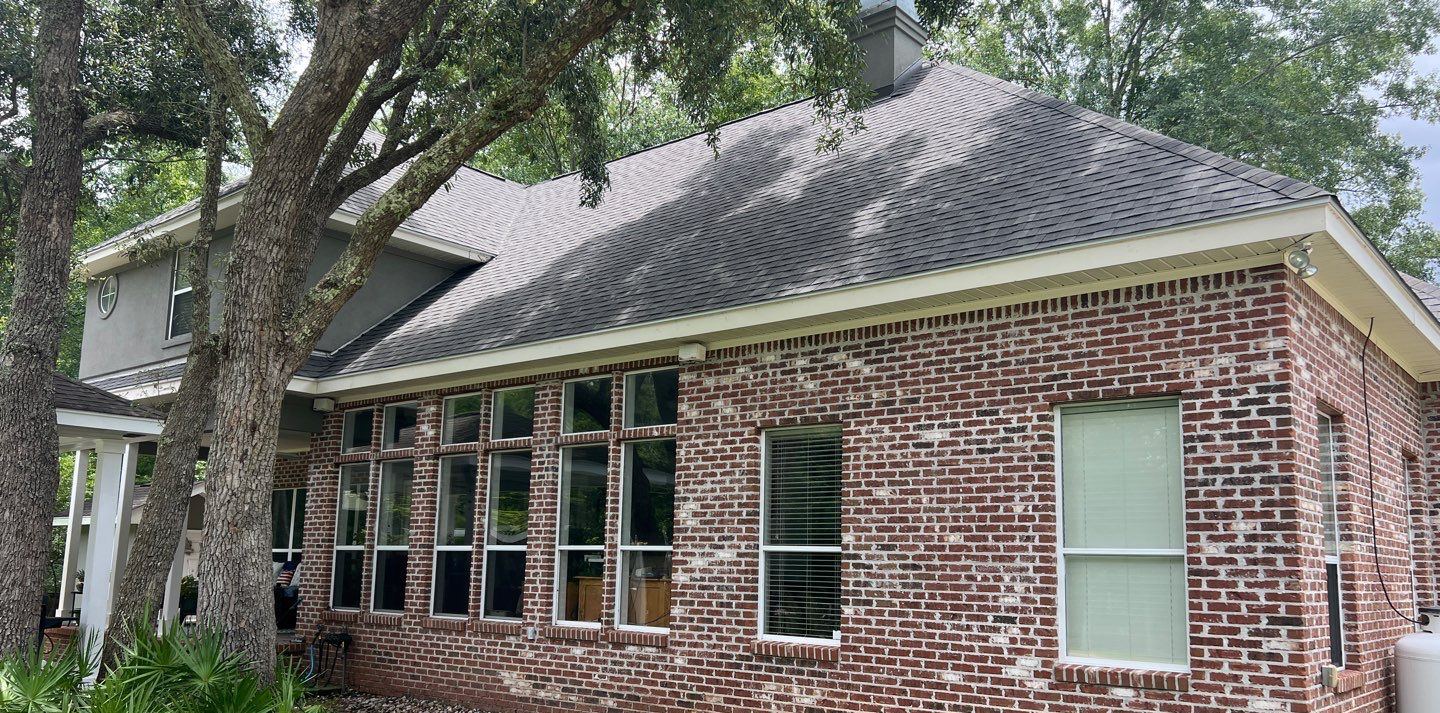 Side of the Biloxi home and its sunroom windows under the new Georgetown Gray roof