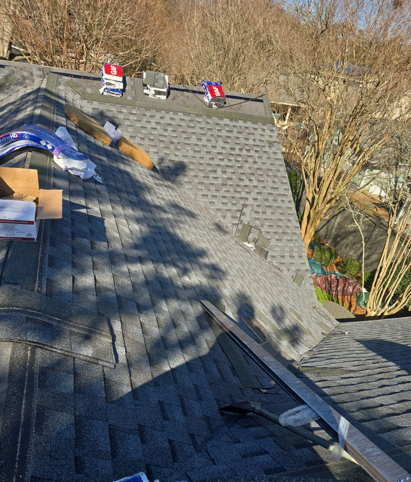 Pewter Gray shingles going on over self-adhering ice-and-water membrane on the Gulfport roof, crew at work
