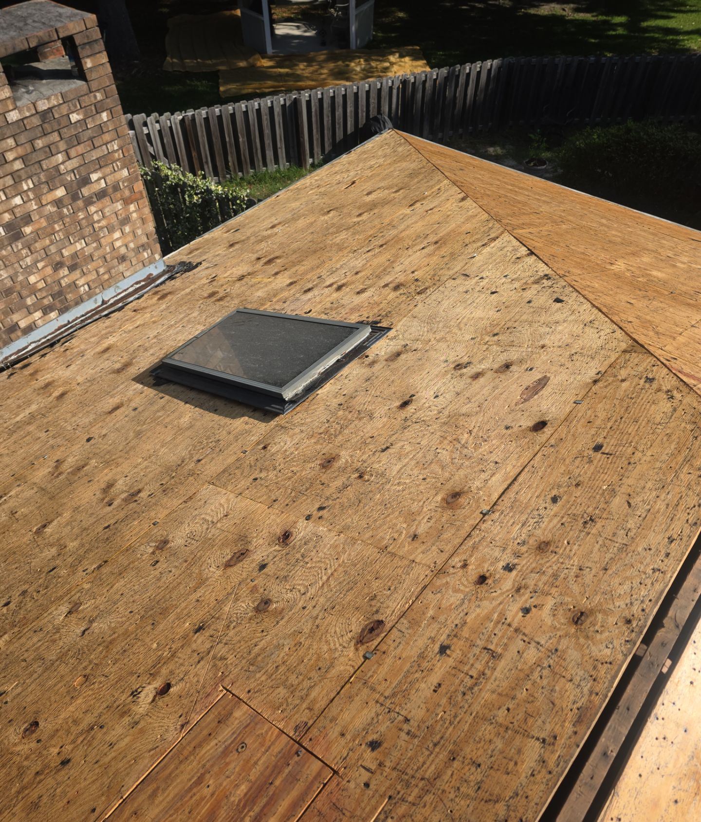 A removed skylight opening covered with new plywood on the Ocean Springs roof deck, ready for membrane