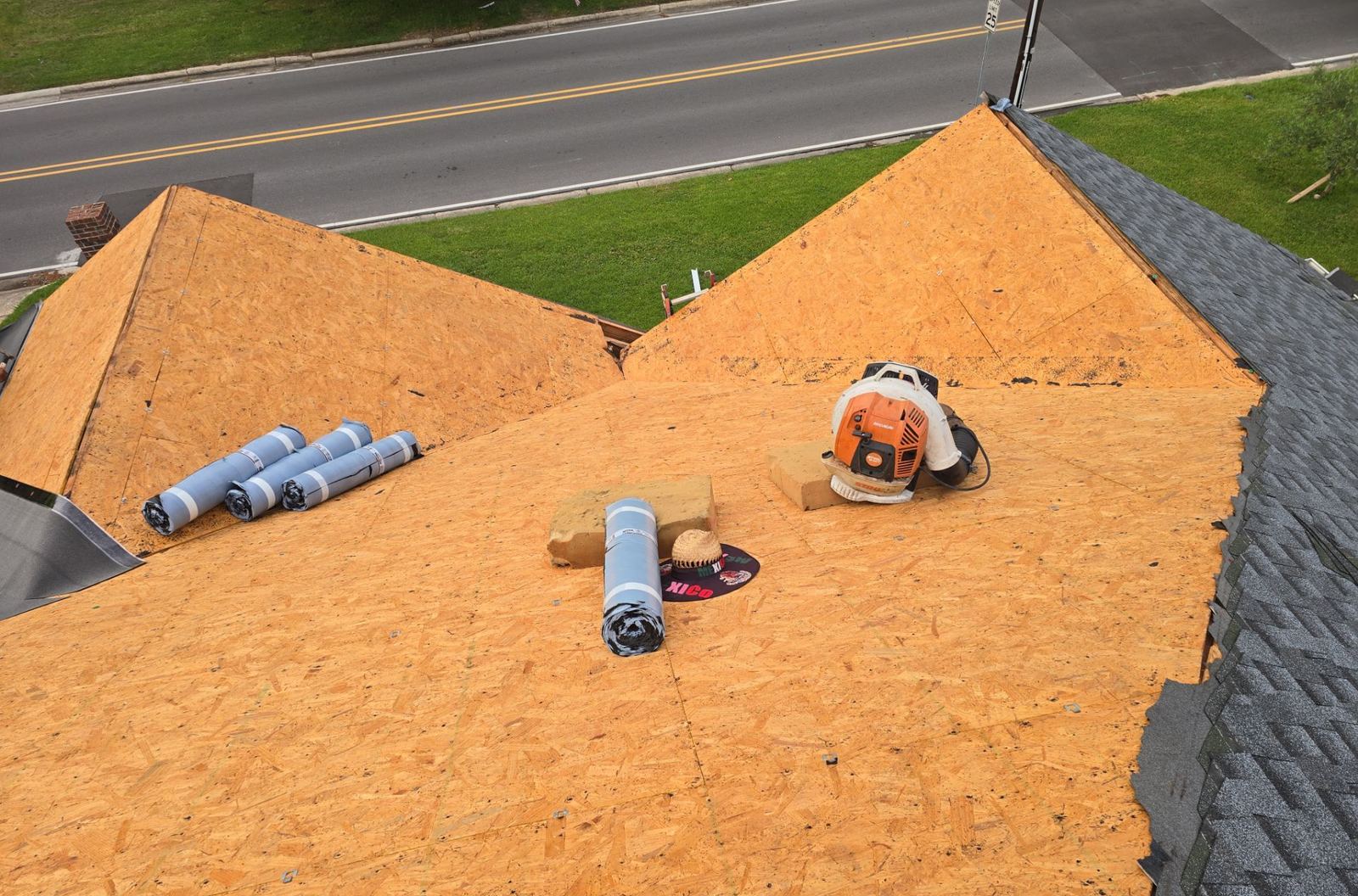 The bare roof deck of the Pascagoula home inspected and ready, rolls of ice-and-water membrane staged on it