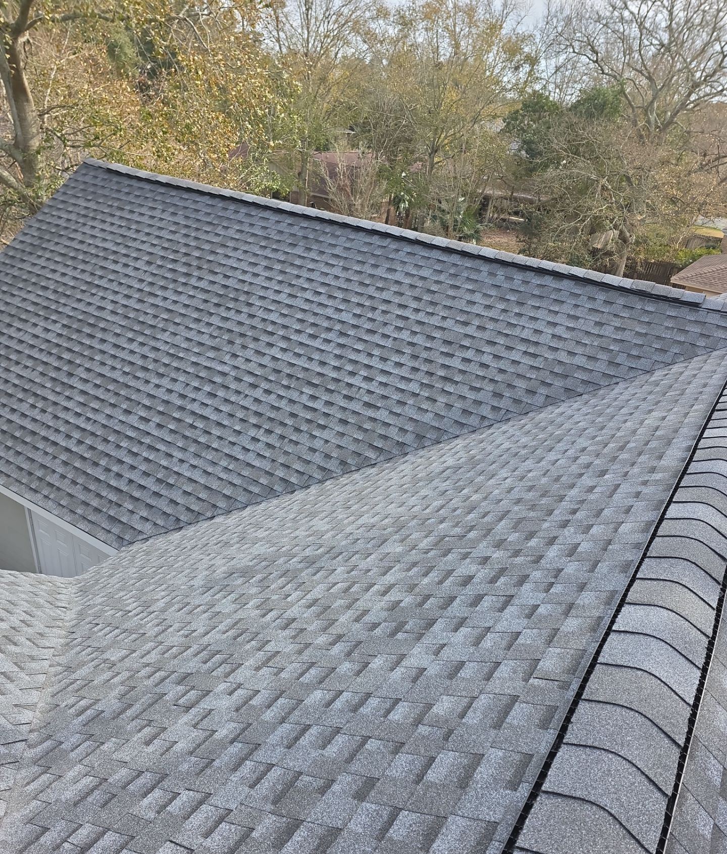 The new Pewter Gray shingle field and ridge on the Gulfport home with the neighborhood beyond, February 4