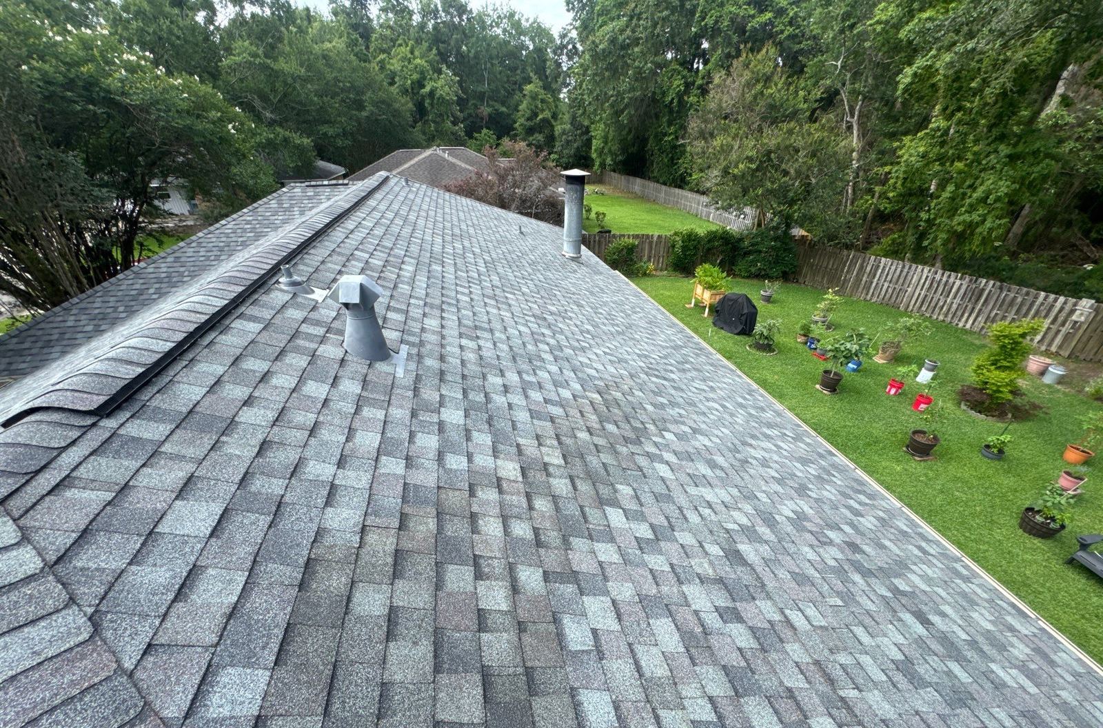 The finished Colonial Slate ridge and new vent flashing on the Long Beach roof, the back garden below