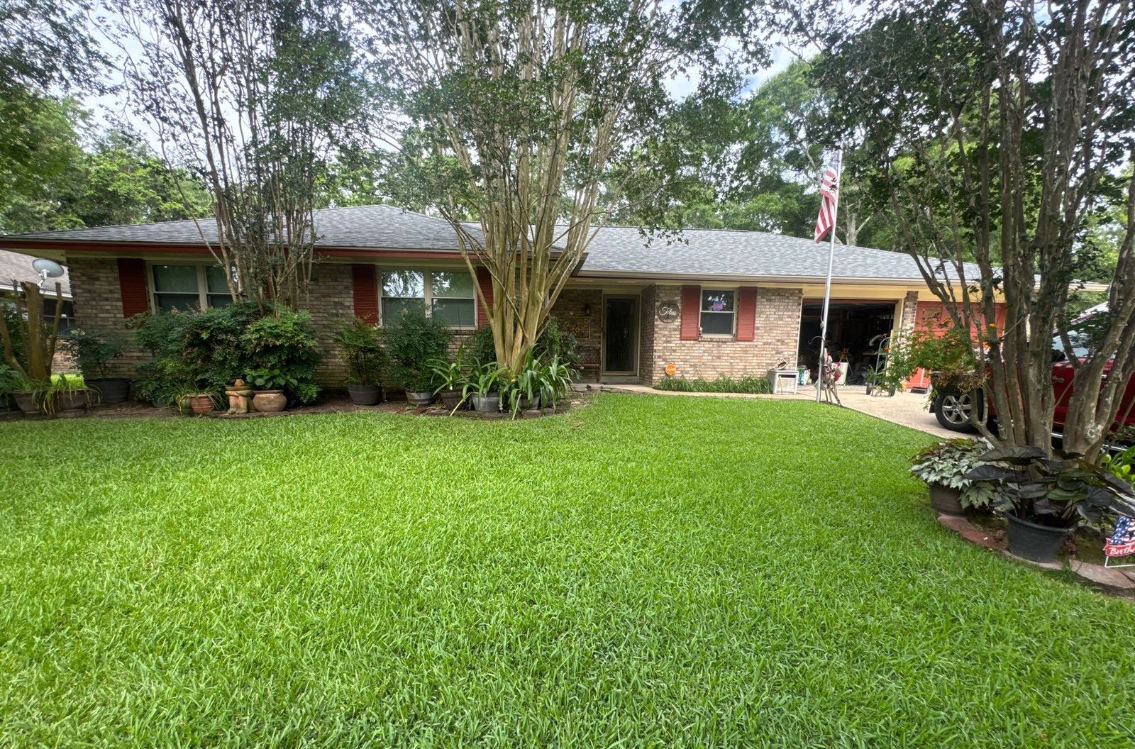 The brick Long Beach home from the front lawn with its completed Colonial Slate roof