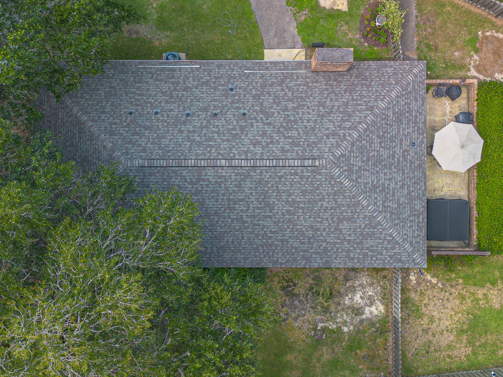 Straight-down aerial of the main house roof showing the new shingle field, ridge and chimney