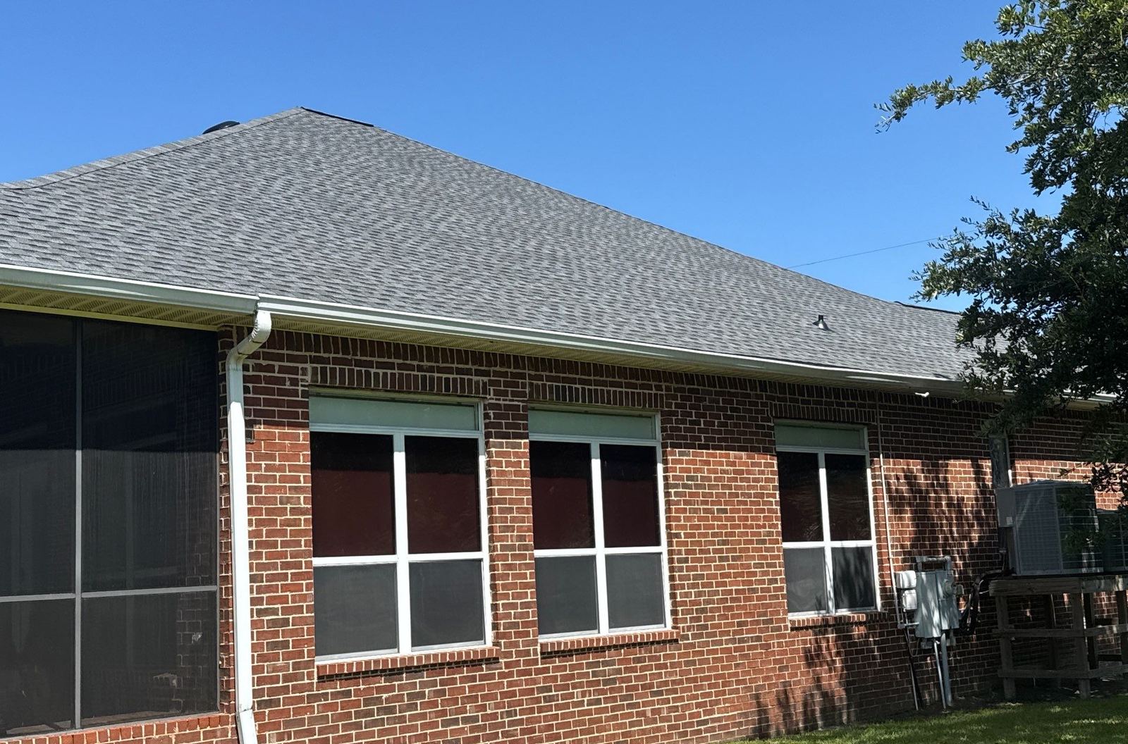 Rear of the brick Pascagoula home and its screened porch under the new Pewter Gray shingle roof a month on