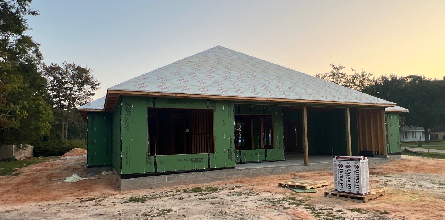 The Ocean Springs new build at framing stage with a bare roof deck and sheathed walls before the roof went on