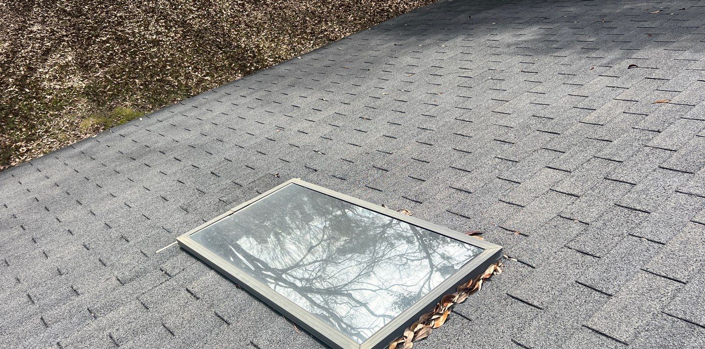 The old three-tab shingle roof on the Ocean Springs house before replacement, with one of the two leaking skylights