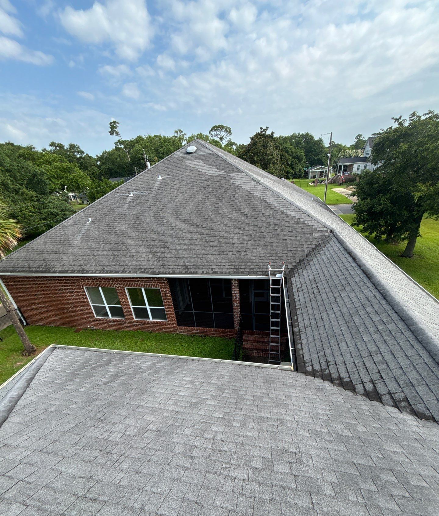 The aging shingle roof of the Pascagoula home from the ridge at the June 25 inspection, the front yard and fountain below