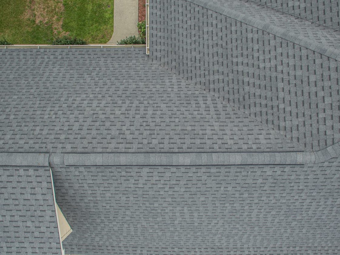 Architectural shingle field laid in staggered courses with finished hips and ridge cap on a Diamondhead Mississippi roof replacement