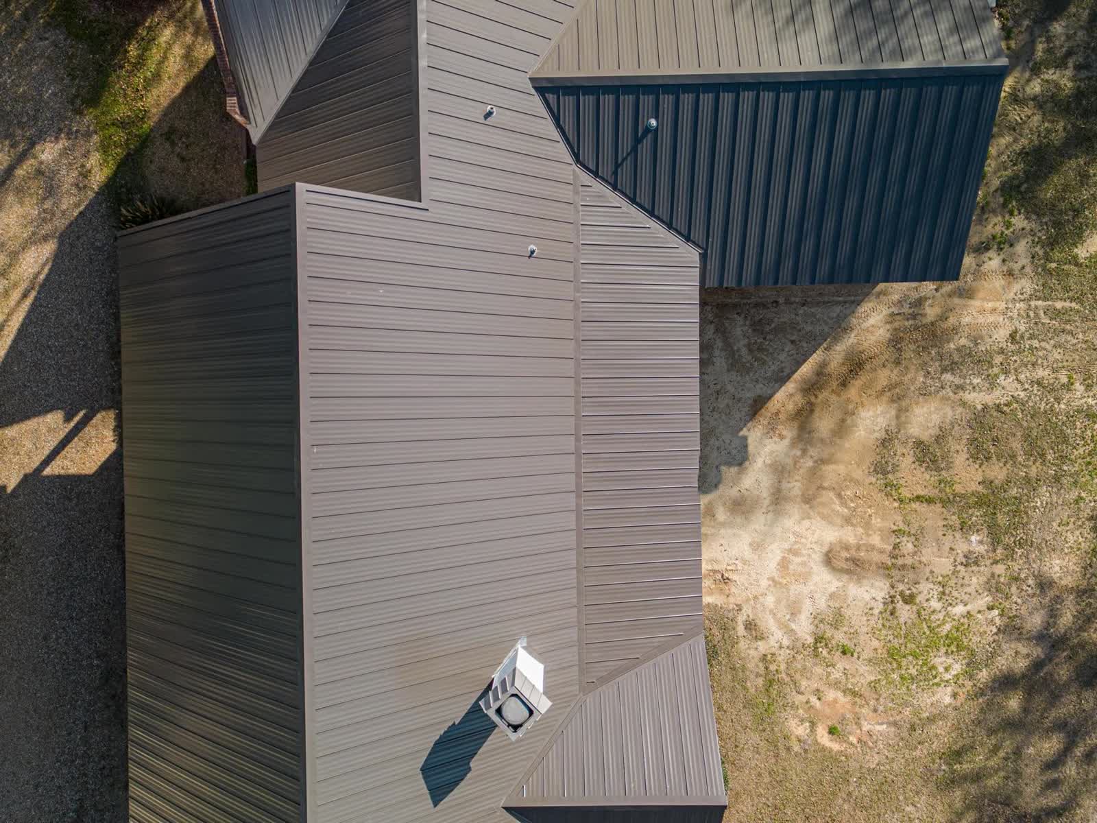 Standing seam metal roof planes meeting cleanly on a Pass Christian, Mississippi home, photographed from directly above