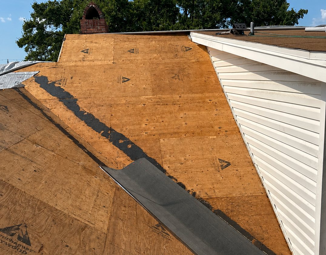 Self-adhering ice-and-water shield rolled up the valley on a bare plywood deck before the field underlayment