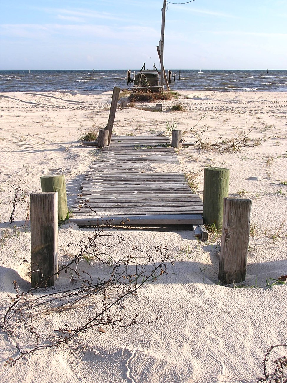 A weathered wooden walkway onto the sand at Waveland beach Mississippi
