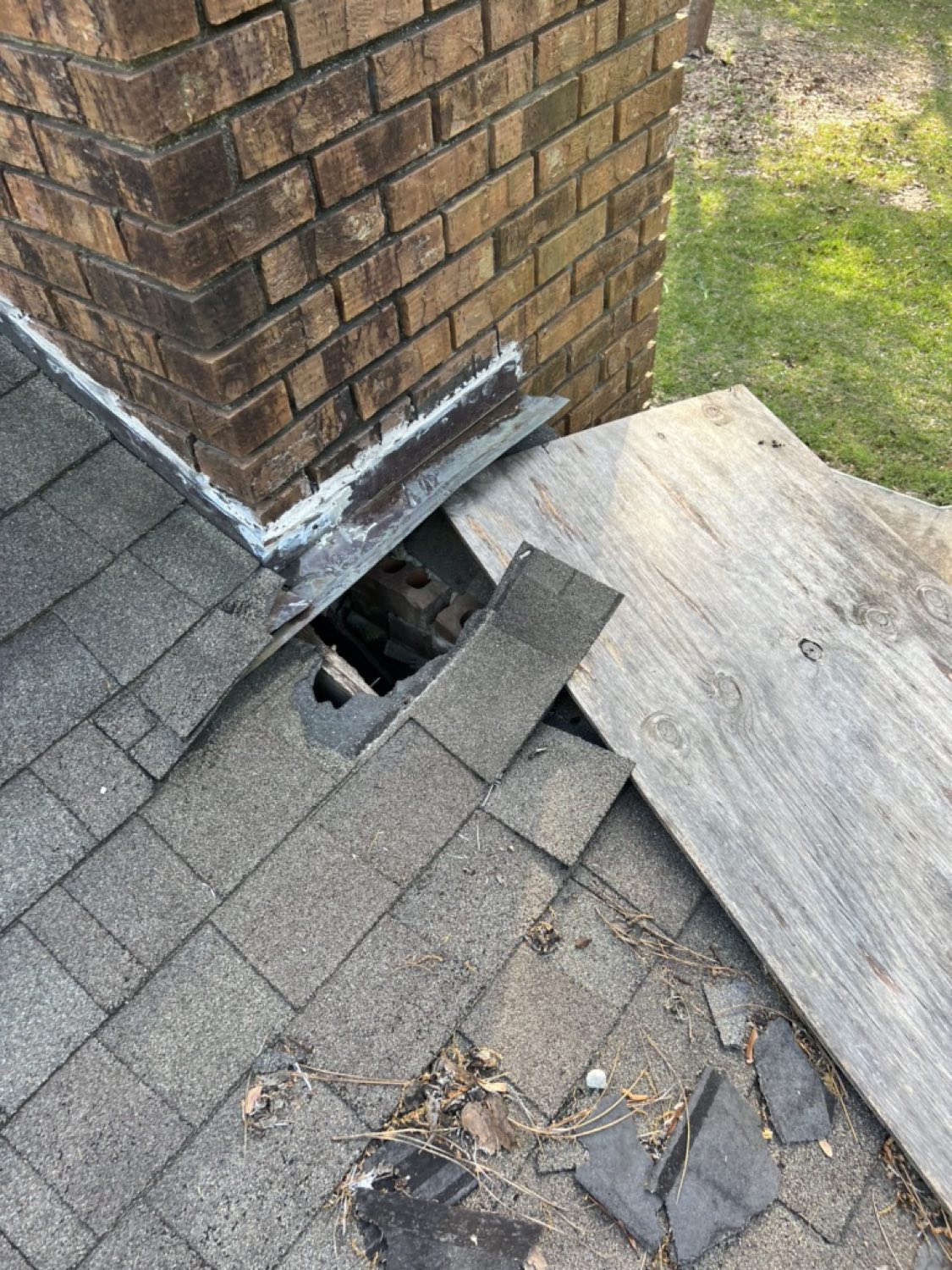 Failed chimney flashing and torn shingles exposing the roof deck on a Gulfport Mississippi home, before repair