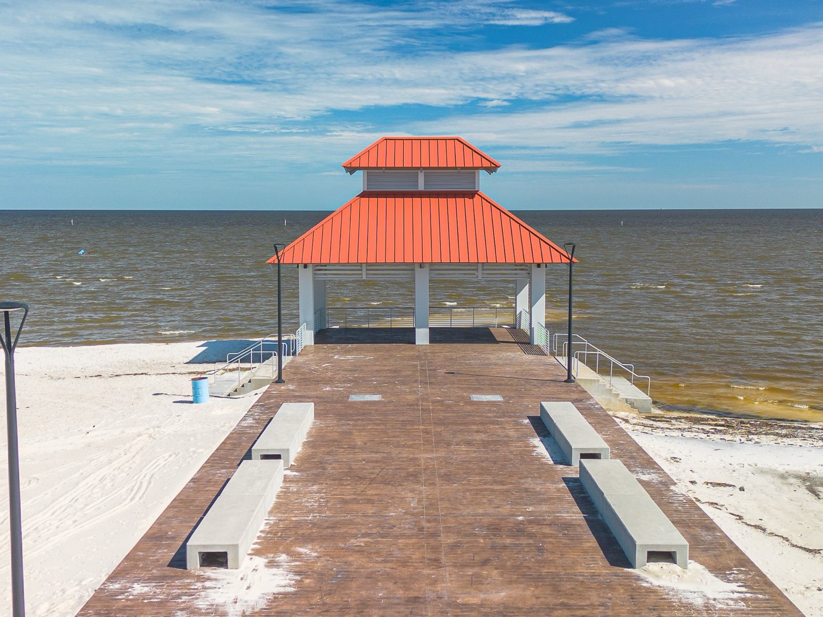 Red standing seam hip roof on the Coffee Creek pavilion in Mississippi installed by Gulf South Roofing, aerial view